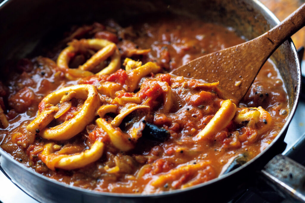 『SPICY CURRY 魯珈』店主・齋藤絵理さんから教わる、夏の食欲をそそるイカのトマトカレー。 | トマト缶を入れ、このくらい全体がなじんだら生バジルと生クリームを入れて完成。