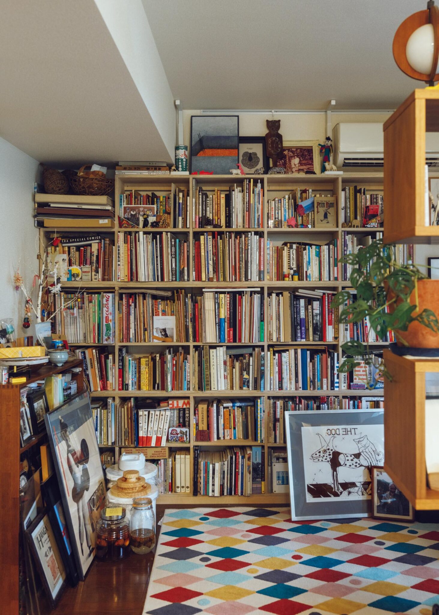 夜の古書店で、未知の本と出合う。歌人・穂村 弘さんの本棚と、読書の時間の見つけ方。 | 書棚には、ビジュアル・アートブックがオブジェとともに並ぶ。他に書斎と書庫も持つ穂村さん。そちらには仕事に関連する本の割合が高い。