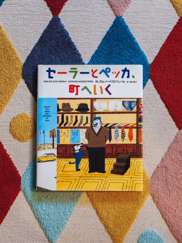 歌人・穂村 弘さんが選ぶ、ずっとそばに置いておきたい本。 | 『セーラーとペッカ、町へいく』
作・絵 ヨックム・ノードストリューム
訳 菱木晃子 (偕成社)
画家、コラージュ作家、イラストレーターとして活動しているスウェーデンのアーティスト、ヨックム・ノードストリュームのシリーズ作。引退した船乗りのセーラーと犬のペッカの日常が描かれている。「犬と人間が対等に友達というところがいい。ともに街に繰り出し、新しい服を買ったり、床屋さんに行ったりするんだけれども、ついでにタトゥーを入れようとする。これが衝撃で。日本の絵本でこのシーンは絶対ないと思うので印象に残り続けています」 歌人・穂村 弘さんが選ぶ、ずっとそばに置いておきたい本。