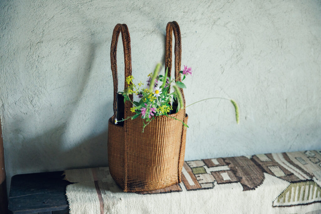 ベトナムで見つけた農具かごを花器に見たてて。華道家の片桐功敦さんの住まいにて。