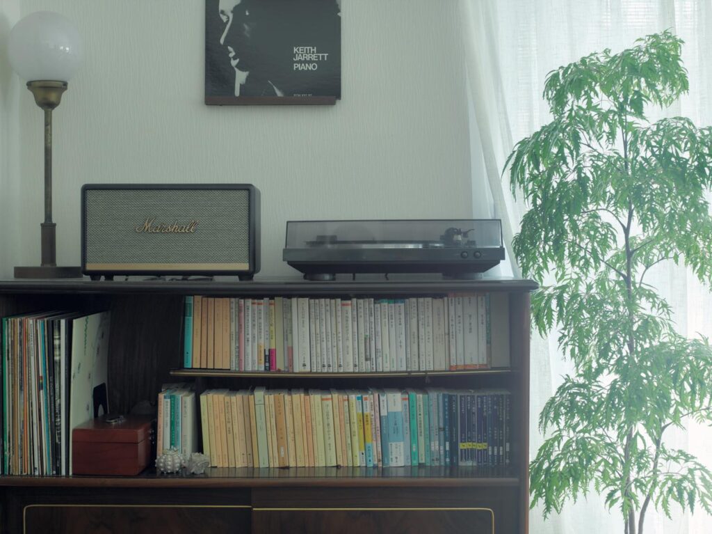 知見を広げてくれる、“聴く読書“の世界。文筆家・塩谷 舞さんの暮らしの本棚と、読書の時間の見つけ方。 | 〈Audible〉の再生は、スマートフォンから〈マーシャル〉のスピーカーに繋いで。「部屋の空間全体にナレーションが行き届くので家事をしながらでも、スムーズに聴きやすいです」 知見を広げてくれる、“聴く読書“の世界。文筆家・塩谷 舞さんの暮らしの本棚と、読書の時間の見つけ方。