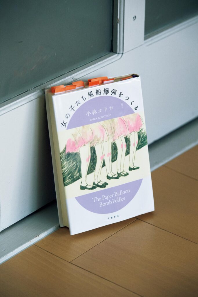 読書の合間に生活をする。作家・永井玲衣さんの暮らしの本棚と、読書の時間の見つけ方。 | 『女の子たち風船爆弾をつくる』
著 小林エリカ(文藝春秋)
日露戦争後30年が経った東京で、少女たちは完成直後の東京宝塚劇場で少女歌劇に釘付けになっていた。しかしやがて戦争が始まり、彼女たちはあの華やかだった劇場に集められ、兵器となる風船爆弾を作ることになる。「『わたしは』と『わたしたちは』を主語にした、歴史書であり小説、エッセイであり詩でもあるという複合的な本。こういった、見えなくされ、なかったことにされていたことを言葉で引き起こす作品が好きだから、ありがたく読みました」 読書の合間に生活をする。作家・永井玲衣さんの暮らしの本棚と、読書の時間の見つけ方。