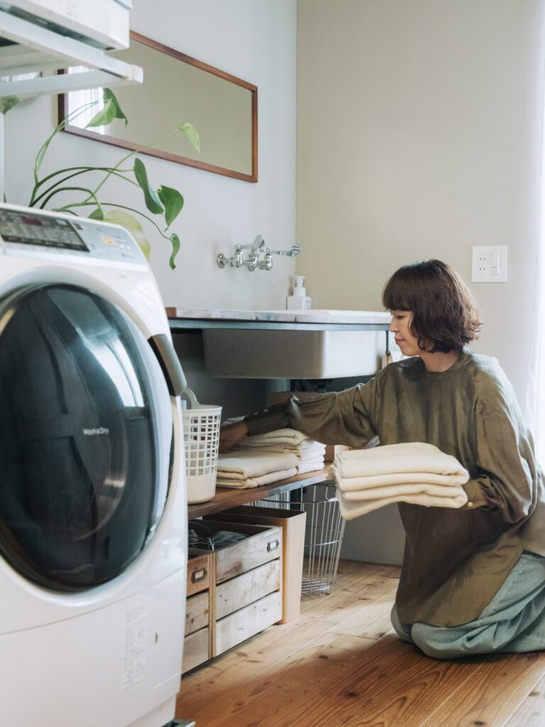 洗濯機が鎮座するランドリースペース。洗濯物を畳んだり身支度したりするだけではなく、ここで一息ついて、脇のベランダへ行き来する猫と戯れることも。