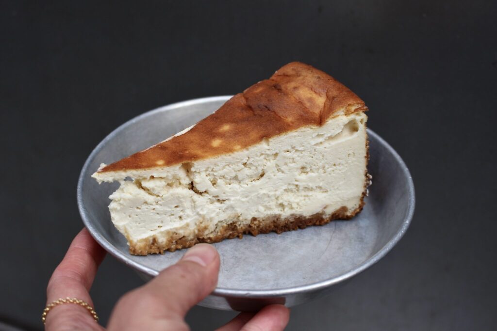 これから『ウィルズ デリ』のサンドイッチを紹介する前に、この店でおいしかったチーズケーキを先出し！ 背中側はベイクドチーズケーキの質感で、中の方はほぼレアチーズケーキ。レモンゼストがちょっと入って、甘みも程よく、とても好みです。川村明子