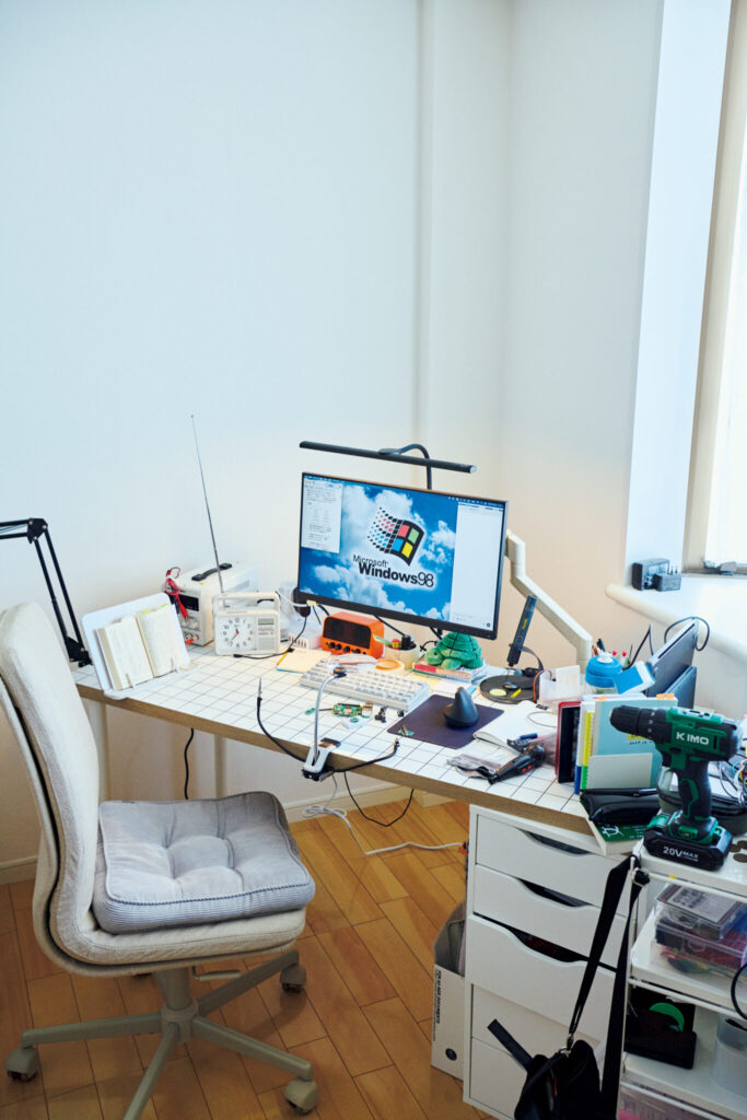 すべてが効率的で、取りやすい位置に。無駄づくり発明家・藤原麻里菜さんの心地よい仕事場。〈IKEA〉の天板と脚と引き出しを合わせ作業台に。ワゴンには電動ドリルも。PCはMacだが、モニターの壁紙はWindows 98。 | 〈IKEA〉の天板と脚と引き出しを合わせ作業台に。ワゴンには電動ドリルも。PCはMacだが、モニターの壁紙はWindows 98。 すべてが効率的で、取りやすい位置に。無駄づくり発明家・藤原麻里菜さんの心地よい仕事場。〈IKEA〉の天板と脚と引き出しを合わせ作業台に。ワゴンには電動ドリルも。PCはMacだが、モニターの壁紙はWindows 98。