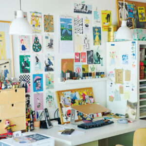 ポストカードやフライヤーが机を彩る。北欧ジャーナリスト・森百合子さんのデスク。ランプはデンマークの〈ルイスポールセン〉。座る位置に合わせてふたつ吊るすことで、自分が影にならず手元をきちんと照らすことができる。