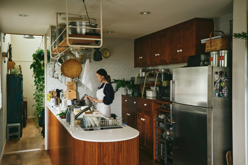 手が届く頭上に吊り棚を取り付け、軽めのアルミ鍋や計量カップ、ザルやおたまなどをセットした、参鶏湯研究家・脇もとこさんのキッチン。 手が届く頭上に吊り棚を取り付け、軽めのアルミ鍋や計量カップ、ザルやおたまなどをセットした、参鶏湯研究家・脇もとこさんのキッチン。