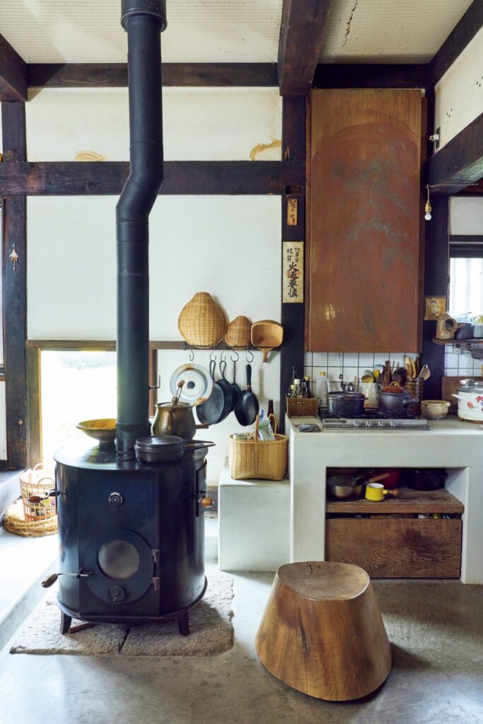 築150年のお勝手を、朗らかな台所に。古民家を改修した、心地よい台所。築150年の古民家だというのに、思いがけず明るい台所だ。正面に設けられた明かり取りの窓から、やわらかな光が注ぎ込んでいる。 台所の主は、飛騨高山の田園に暮らす朝倉佳子さん。夫の圭一さんと民藝の器を扱う『やわい屋』を営む。移築した江戸末期建造の平屋には、店舗とギャラリー、私設図書館、居住スペースが収まっており、全幅の信頼を置く大工の渡邊覚さんと相談をしつつ、4度の改修を経て現在の形に辿り着いた。 | 台所と居間を繋ぐスペースには、長野県中川村在住のイエルカ・ワイン制作の大きな薪ストーブが。冬になると、ピザやグラタンなどストーブオーブンを使った料理を楽しむ。 築150年のお勝手を、朗らかな台所に。古民家を改修した、心地よい台所。築150年の古民家だというのに、思いがけず明るい台所だ。正面に設けられた明かり取りの窓から、やわらかな光が注ぎ込んでいる。 台所の主は、飛騨高山の田園に暮らす朝倉佳子さん。夫の圭一さんと民藝の器を扱う『やわい屋』を営む。移築した江戸末期建造の平屋には、店舗とギャラリー、私設図書館、居住スペースが収まっており、全幅の信頼を置く大工の渡邊覚さんと相談をしつつ、4度の改修を経て現在の形に辿り着いた。 | 台所と居間を繋ぐスペースには、長野県中川村在住のイエルカ・ワイン制作の大きな薪ストーブが。冬になると、ピザやグラタンなどストーブオーブンを使った料理を楽しむ。