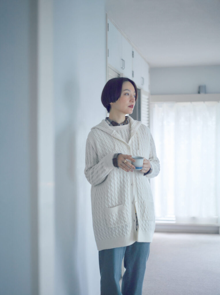 しっとりとした冬の朝に溶け込む、美しい光沢感とソフトな風合いが魅力のケーブルニット。天然繊維特有の吸湿性、放湿性を併せ持つ、繊細で上質なエクストラファインメリノウールを使用し、驚くほどやわらかな肌触りと着心地。ニットをレイヤードして、奥行きのある装いを。セーター￥48,400、ベスト￥50,600、シャツ￥36,300、パンツ￥33,000 (以上マドモアゼルノンノン) その他本人私物 