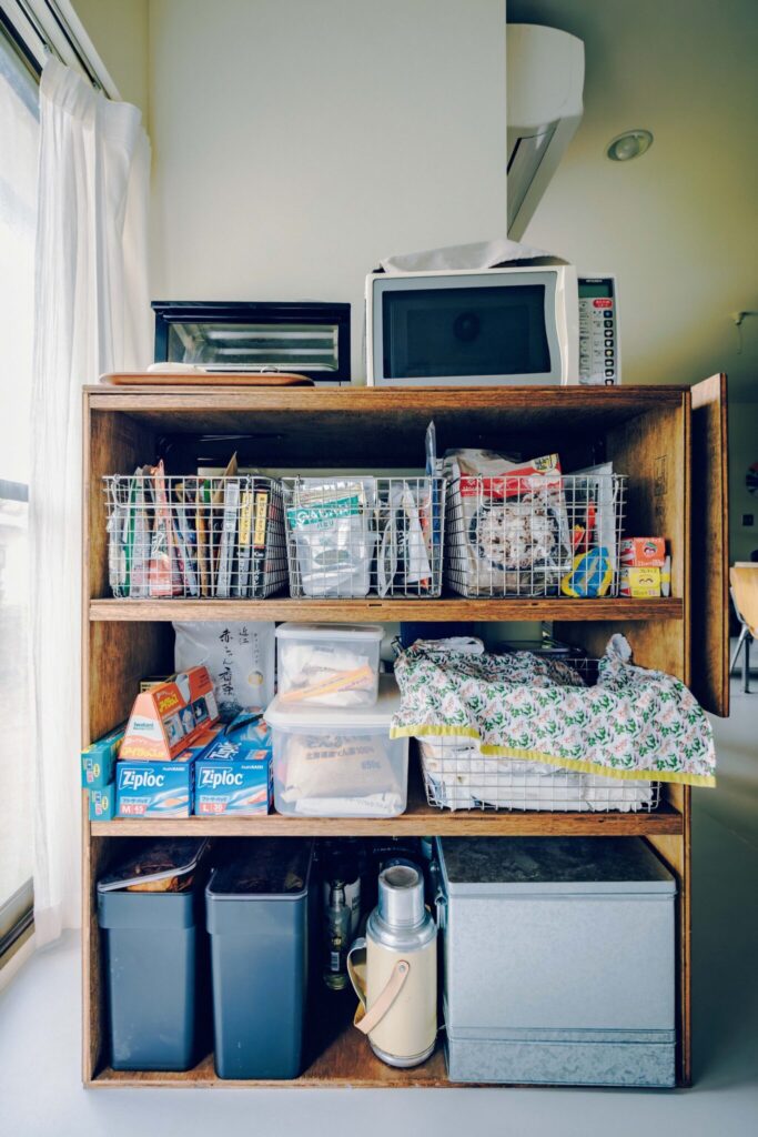 家事の動線を一直線におさめる。アートが彩る開放的なアイランドキッチン。 | 電子レンジやトースター、消耗品などを置いている棚は、学生時代に自作したもの。手作りやDIYも好き。