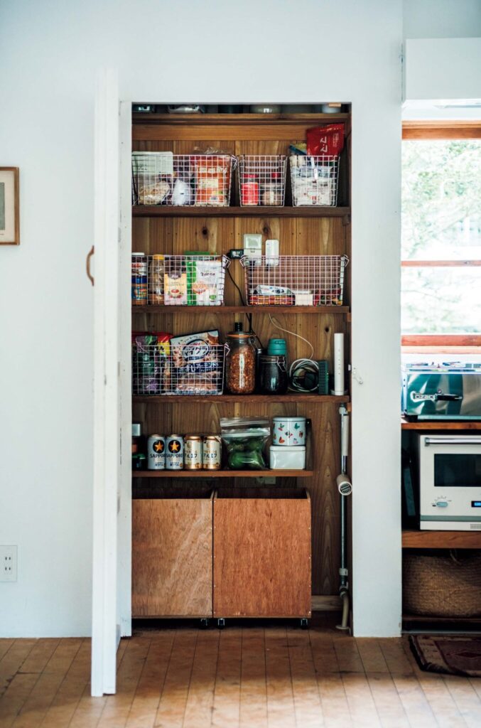 どの角度から眺めても、愛せる場所。自然と家族の真ん中にある、台所。 | ガス台があるすぐそばに造作したパントリー。〈無印良品〉で購入したワイヤーバスケットに調味料、麺類、粉類などを分類してまとめた。