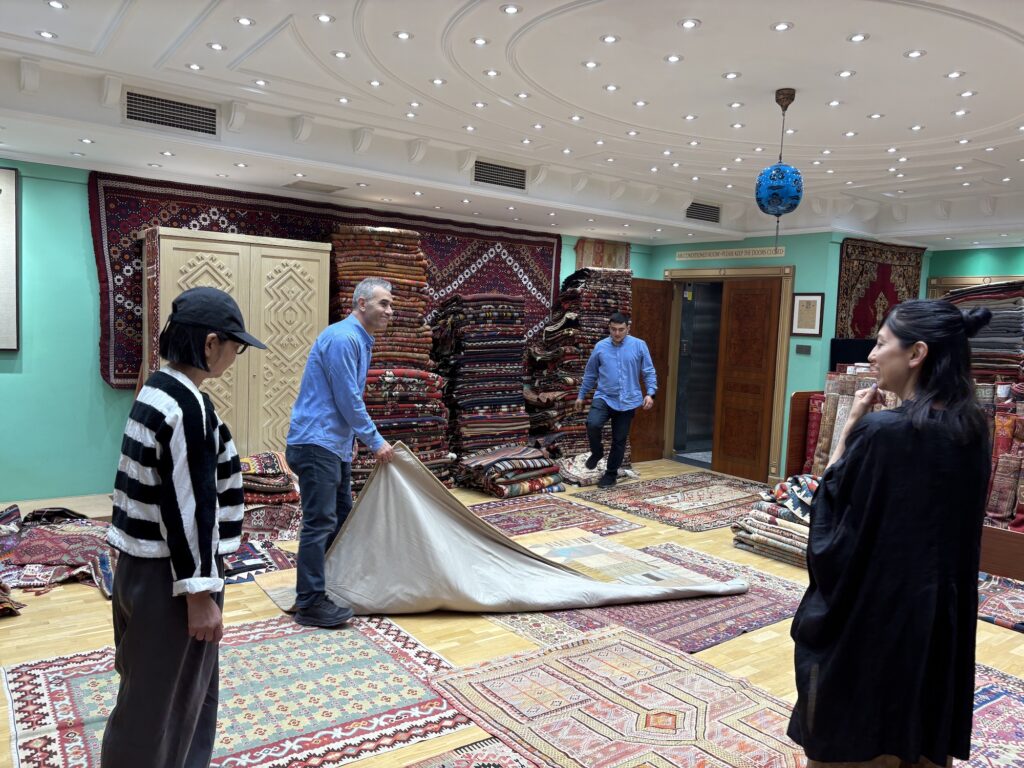 スタイリスト・石井佳苗さんと平井かずみさんが教えてくれた、ラグの楽しみ。 | ラグ店での買付の様子。「気になったものをすべて敷いてもらって、その中から吟味。値段交渉も頑張りました」
