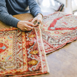 スタイリスト・石井佳苗さんと平井かずみさんが教えてくれた、ラグの楽しみ。 | 机の上に広げてくれたのは、毛足の長いパイル織のトライバルラグ。「ウール地で柔らかく、調湿機能もあるので夏は湿気を調整してくれて、冬は足元を温めてくれる。一年中使えるアイテムです」と石井さん。