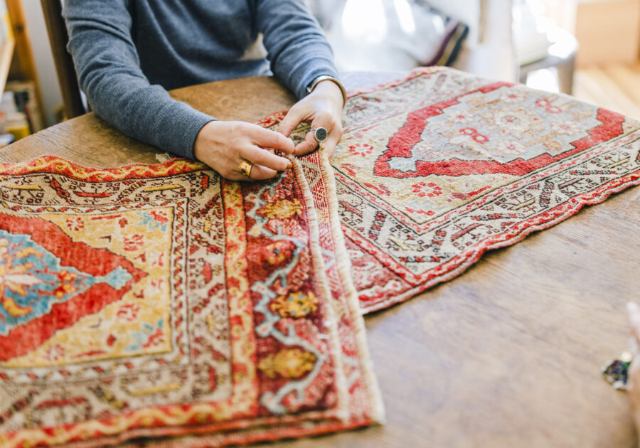 スタイリスト・石井佳苗さんと平井かずみさんが教えてくれた、ラグの楽しみ。 | 机の上に広げてくれたのは、毛足の長いパイル織のトライバルラグ。「ウール地で柔らかく、調湿機能もあるので夏は湿気を調整してくれて、冬は足元を温めてくれる。一年中使えるアイテムです」と石井さん。