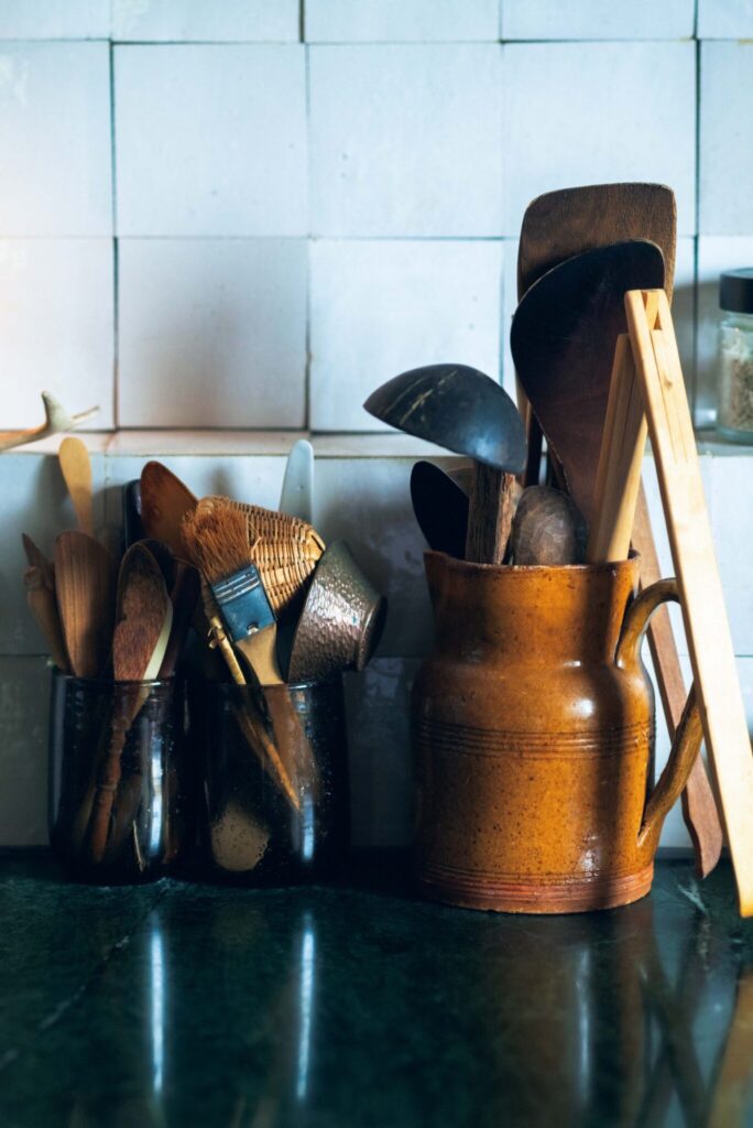 周囲の自然に溶け込む、部材の色に。菓子研究家・長田佳子さんの台所。 | 古道具のピッチャーに天然素材のヘラやお玉を収めた。