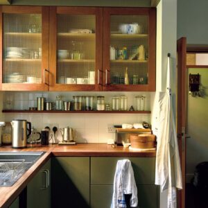 145_p078-085_マーガレット・ハウエル_02 | シンク横の棚には普段使いの食器を収納。取り出しやすく、使い勝手もいい。食材の保存はガラスの瓶に。毎日使う場所だから自分らしい空間に整えることを大切にしている。
