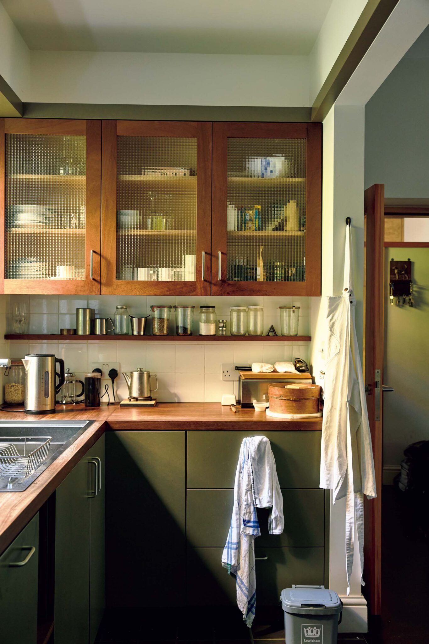 145_p078-085_マーガレット・ハウエル_02 | シンク横の棚には普段使いの食器を収納。取り出しやすく、使い勝手もいい。食材の保存はガラスの瓶に。毎日使う場所だから自分らしい空間に整えることを大切にしている。 145_p078-085_マーガレット・ハウエル_02 | シンク横の棚には普段使いの食器を収納。取り出しやすく、使い勝手もいい。食材の保存はガラスの瓶に。毎日使う場所だから自分らしい空間に整えることを大切にしている。