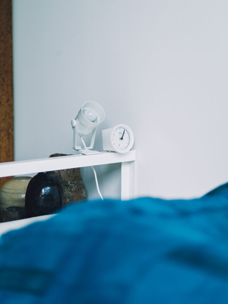 圧迫感がなく、ホテルの一室のような部屋。スタイリスト・竹内万貴さんの暮らしのこだわり。 | 目覚まし時計は底面にマグネットを付けて固定。クリップ式のライトを使うなど、サイドテーブルがなくてもいいよう工夫。