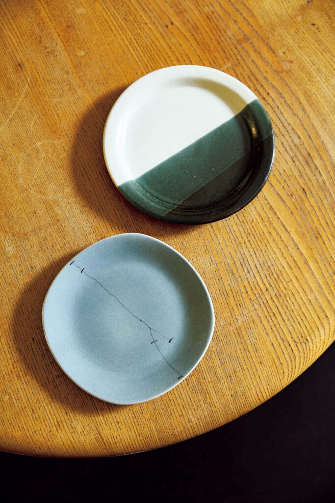 145_p078-085_マーガレット・ハウエル_15 | 日本で金継ぎしたプレート
白と緑のプレートはアフリカのもの。水色の器はジャンブルセールで入手。どちらも割れたり欠けたりしたが、水色は金
継ぎ作家の黒田雪子に依頼。新たな魅力が生まれたという。 145_p078-085_マーガレット・ハウエル_15