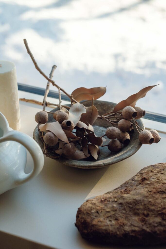 北海道の豊かな自然の中で、有機的に暮らす。料理家・エッセイストの藤原奈緒さんが住む築60年の家。 | 天然のドライボタニカルをディスプレイに、海で拾った綺麗な石は箸置きに。北海道での暮らしは「美しいものはいつも自然の中にある」と教えてくれる。