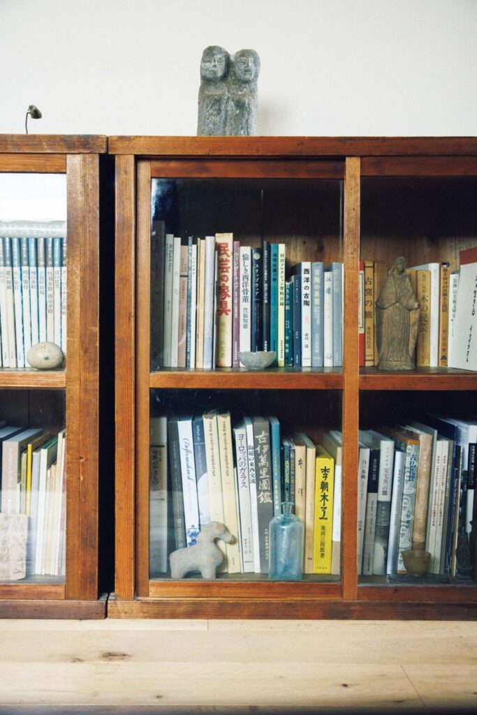選び抜いた古物のひとつとして存在する家。ギャラリー『kankakari』主宰の鈴木良さんが住む築100年の京町家。 | 水屋箪笥を上下に分けた本棚。双体道祖神や石斧、ローマ時代の残欠などが飾られている。 選び抜いた古物のひとつとして存在する家。ギャラリー『kankakari』主宰の鈴木良さんが住む築100年の京町家。 | 水屋箪笥を上下に分けた本棚。双体道祖神や石斧、ローマ時代の残欠などが飾られている。