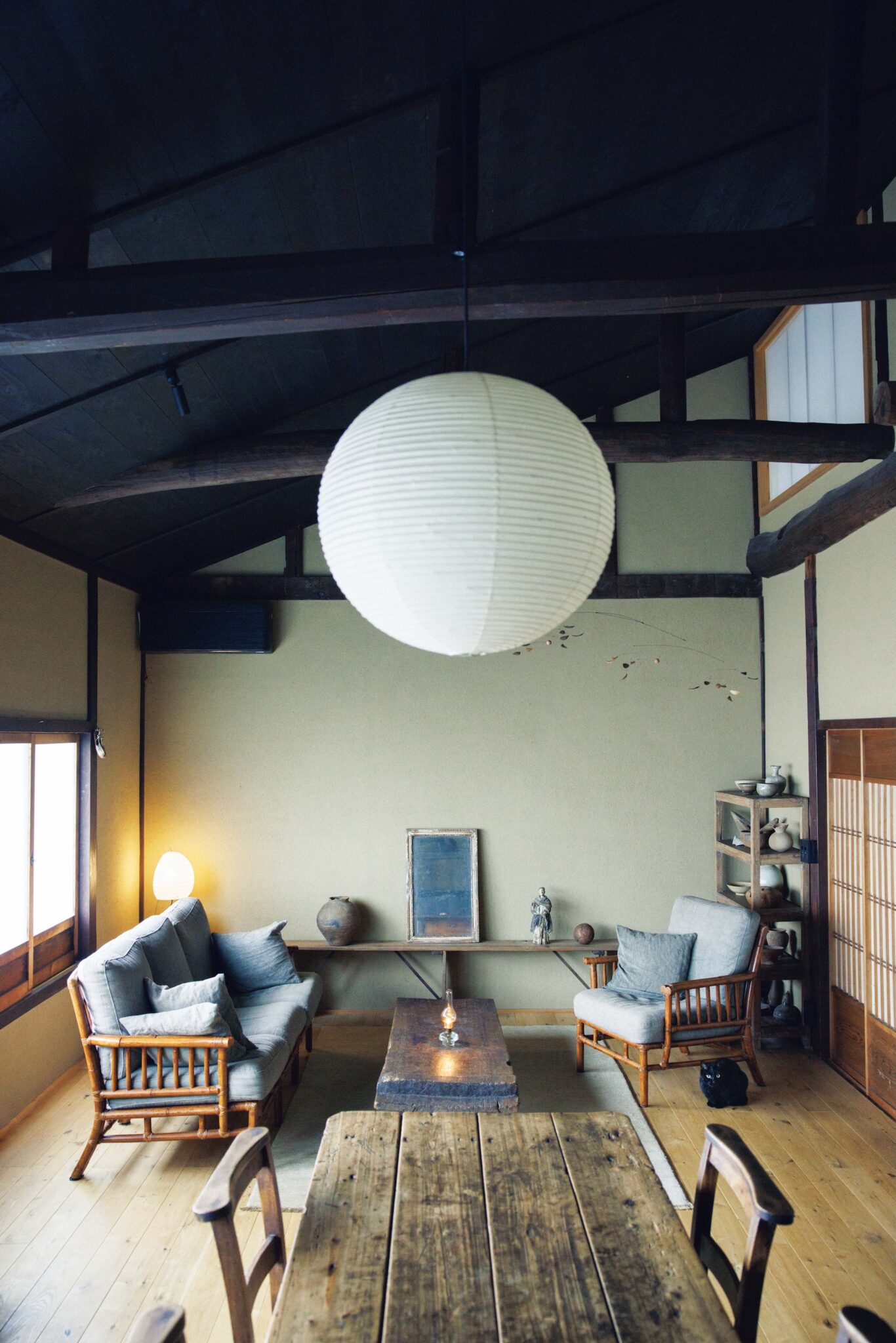 選び抜いた古物のひとつとして存在する家。ギャラリー『kankakari』主宰の鈴木良さんが住む築100年の京町家。 | 鈴木良さん、真実さんが暮らすキッチンから見るリビングの眺め。ソファは譲り受けたのち草木染の生地に張り替えている。床暖房を考慮し強さのあるオークを床材に。