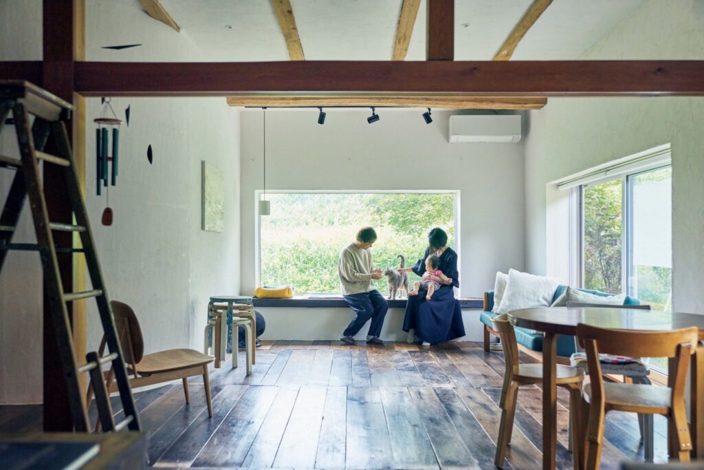 弧を描く白壁を、古民家暮らしの象徴に。〈JAPONISME〉運営の白石さん夫妻が住む築70年の家。 | リビングの大きな窓には腰掛けスペースも。白石達史さん、実果さんと1歳の与和（とわ）くん、愛猫のすず。
