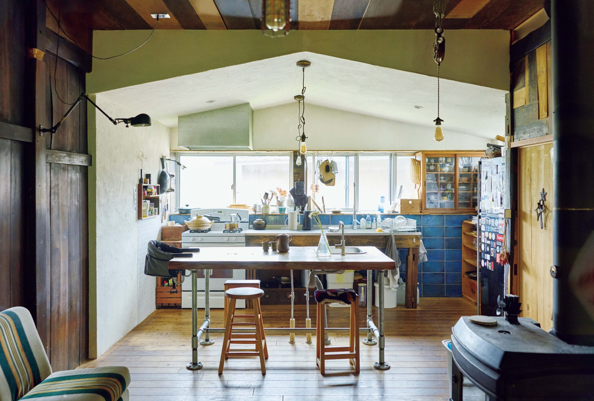 弧を描く白壁を、古民家暮らしの象徴に。〈JAPONISME〉運営の白石さん夫妻が住む築70年の家。 | 時には多くの人が集う明るいキッチン。改修を手がけた当初はインダストリアルデザインが好きだったため、リビングとは少し違う雰囲気なのも楽しい。