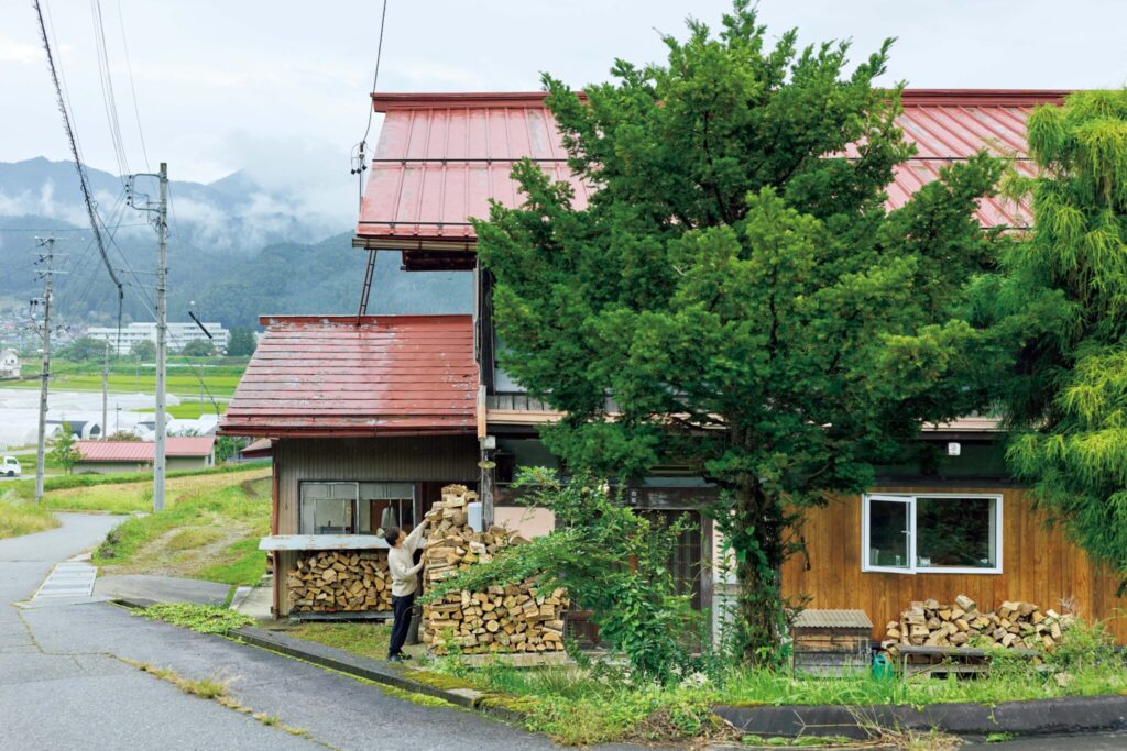 弧を描く白壁を、古民家暮らしの象徴に。〈JAPONISME〉運営の白石さん夫妻が住む築70年の家。 | 秋口の外観。冬に備えてたくさんの薪を用意している。