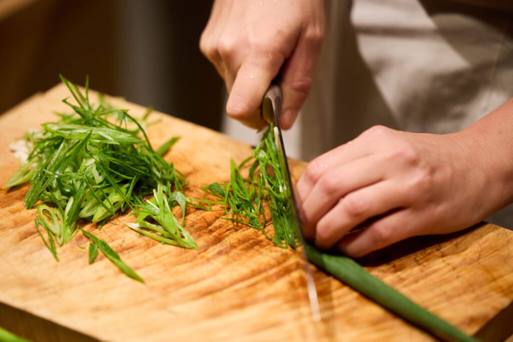 冬にぴったり、体を整える九条ねぎとごぼう鍋のレシピ。写真と文：原田アンナベル聖子 (『KOMB』シェフ＆オーナー) #2 | ①九条ねぎは根を切り落とし、斜めに千切りにする。