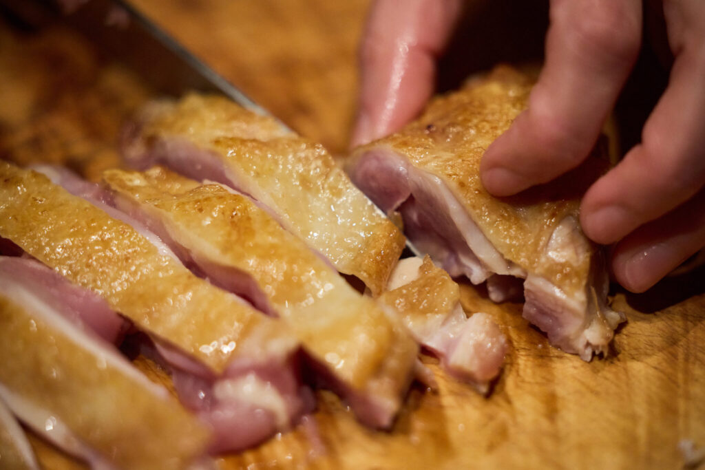 冬にぴったり、体を整える九条ねぎとごぼう鍋のレシピ。写真と文：原田アンナベル聖子 (『KOMB』シェフ＆オーナー) #2 | ④皮に焼き色がついたら取り出し、食べやすい大きさに切る。