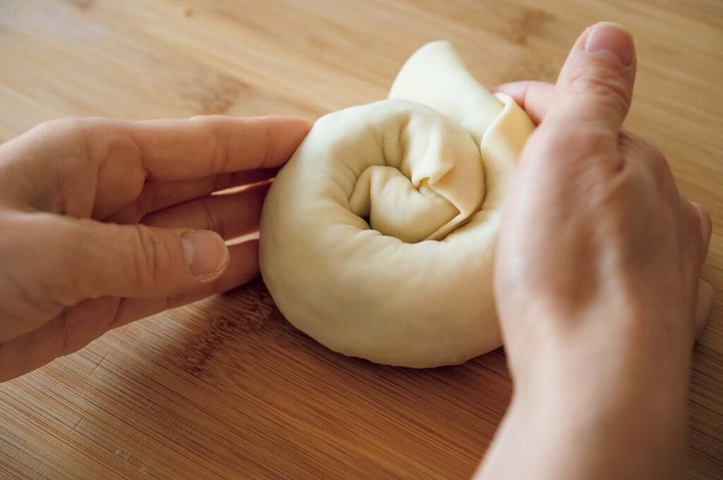 “香のもの”を生かした冬の中華。渡辺有子の料理教室3年目vol.2 | 具をのせて細い筒状にした生地を渦巻き状にしたら端を生地にしっかりつける。 “香のもの”を生かした冬の中華。渡辺有子の料理教室3年目vol.2 | 具をのせて細い筒状にした生地を渦巻き状にしたら端を生地にしっかりつける。