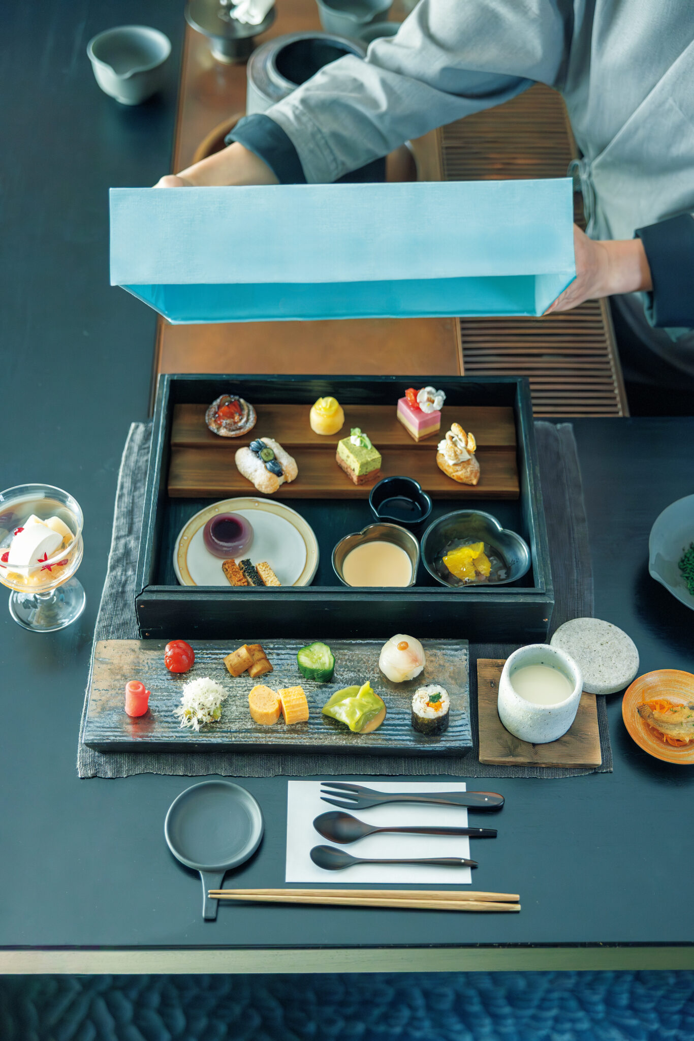 これが「茶請箱」。季節ごとに替わるが、セイボリーは寿司や雲呑、南蛮漬けや季節の漬物、すり流しを含む11種、スイーツは、レモンケーキ、アールグレイとあかももムース、ココナツパンナコッタと桃のグラスを含む11種類。東京・立川の隠れ家茶房『ときと』で、時を忘れて和のティータイムを。 | これが「茶請箱」。季節ごとに替わるが、セイボリーは寿司や雲呑、南蛮漬けや季節の漬物、すり流しを含む11種、スイーツは、レモンケーキ、アールグレイとあかももムース、ココナツパンナコッタと桃のグラスを含む11種類。