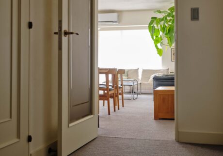 肌触りの良さを楽しむ。不動産会社代表・足立 淳さんに聞いた、心地よく過ごすための空間づくり。 | 玄関を入った廊下からリビングダイニングまで、水回り以外のすべての床をカーペット敷きにリフォームした。