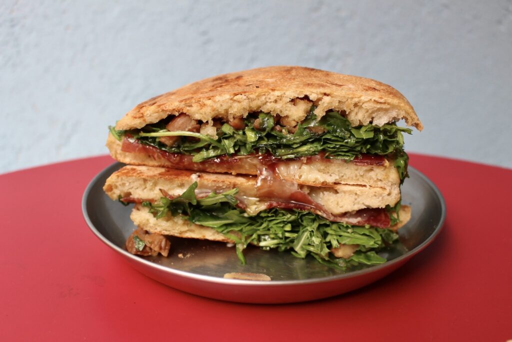 まずは、本誌で紹介した『ペッツォパーネ』のコッパ (豚の生ハム) サンドを。コッパの塩気と、こってりとろんと甘いハチミツ、ほくっと香る栗が織りなすハーモニー。これもまたクセになるおいしさです。 川村明子 サンドイッチ