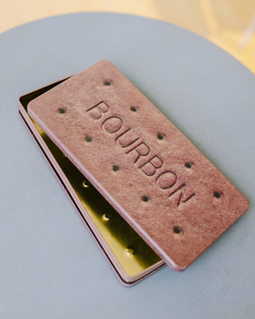 IMG_8408 | 塩川さんがロンドン土産でもらったというバーボンビスケットの缶。少し凹んだ形の側面はクッキーに挟まっているチョコレートを表している。