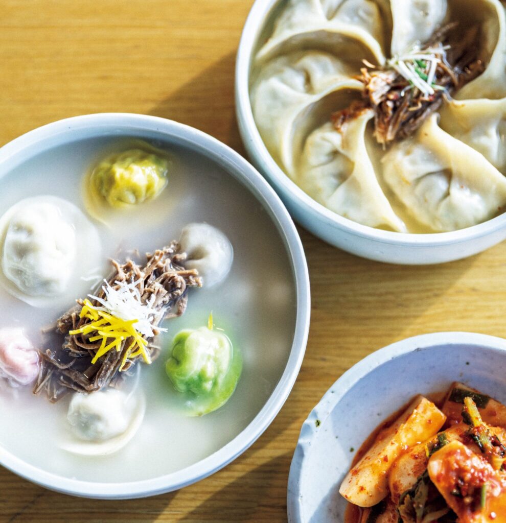 優しい味わいの手作りマンドゥを景色とともに楽しめる。付岩洞の「紫霞ソンマンドゥ」。家族で受け継ぐ、ソウルフルな名店。 | 上は餃子入りスープ、下は餅入り餃子スープ各20,000W。餅は小さな雪だるま形の開城(ケソン)式。餃子は、ほうれん草、ビーツ、人参で色づけ。おかずのキムチと。 優しい味わいの手作りマンドゥを景色とともに楽しめる。付岩洞の「紫霞ソンマンドゥ」。家族で受け継ぐ、ソウルフルな名店。 | 上は餃子入りスープ、下は餅入り餃子スープ各20,000W。餅は小さな雪だるま形の開城(ケソン)式。餃子は、ほうれん草、ビーツ、人参で色づけ。おかずのキムチと。