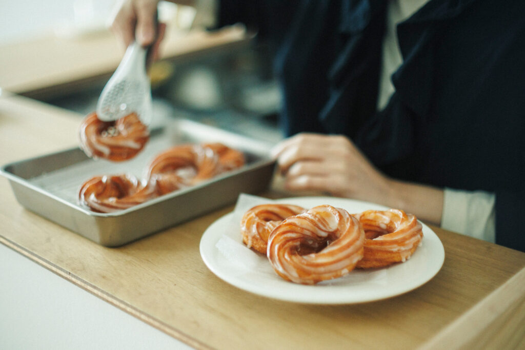 吉田エリアのグロサリー『ベンチ』では、カレーやおやつのイートインもできるのがうれしい。散歩の休憩に、レモンアイシングのフレンチクルーラーを。