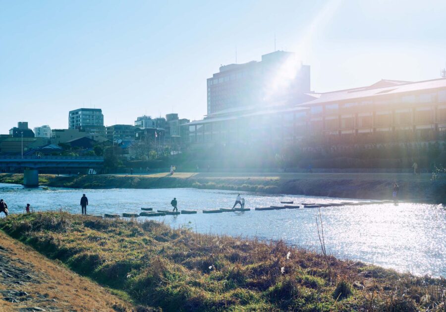 人を引き寄せる、ゆるやかな水辺のリズム。京都・鴨川、ローカルガイド。 | 夷川飛び石 きらめく川面を眺めていると、せわしない気持ちがいつの間にか凪いでいく。天気のいい日に人々がぴょんぴょんと飛び石をつたって川を渡る光景は、このエリアの風物詩だ。なかには千鳥や船をかたどった石もあり、大人も童心にかえっている。「川が流れる街は少なくないけれど、鴨川はどこか特別。大きなサードプレイスのように開かれた河川敷の雰囲気や、対岸がすぐそばに見えるサイズ感がちょうどいい。川そのものだけでなく、川から遠くに望む北の山々も景色の奥行きを感じさせてくれて好きなんです」と酒向さん。吸い寄せられるように、時間が許せば川沿いを歩いてしまうという。「コーヒーを片手にリラックスして。そんな時間を大切にしています」