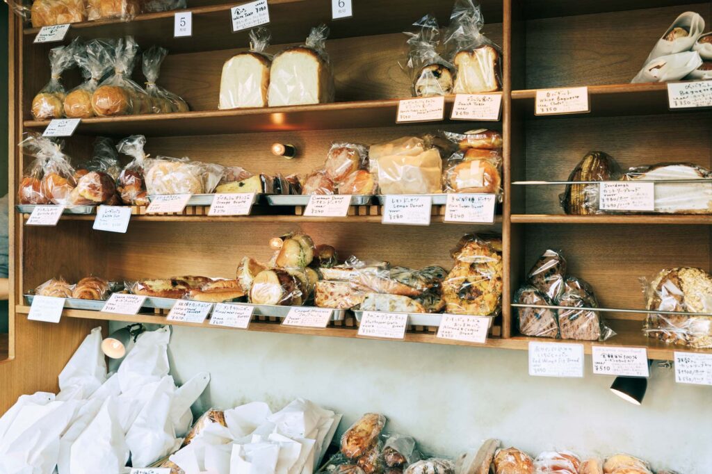 人を引き寄せる、ゆるやかな水辺のリズム。京都・鴨川、ローカルガイド。後編 | コンパクトな空間にぎっしりとパンが並ぶ『ベーカリー ウキ』（京都市上京区俵屋町455）。「おやつパンからボリュームある惣菜パンまで充実。ロールパンなどを手土産にすることも。列がないとつい寄りたくなる」と酒向さん。