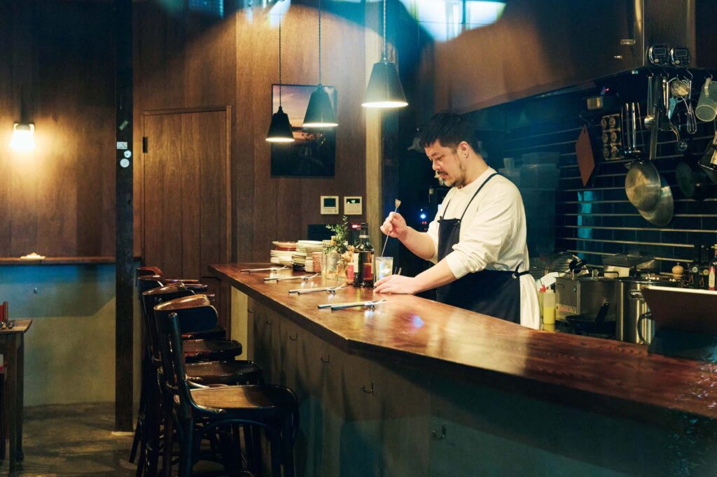 人を引き寄せる、ゆるやかな水辺のリズム。京都・鴨川、ローカルガイド。後編 | 2025年9 月にオープンした『森田倶楽部』（中京区大文字町233）は、ソムリエでもありバーテンダーでもある森田さんによるワインと国産スピリッツのバー。「深夜2 時までの営業
で、いろんな気分の夜を受け止める包容力あるお店です」