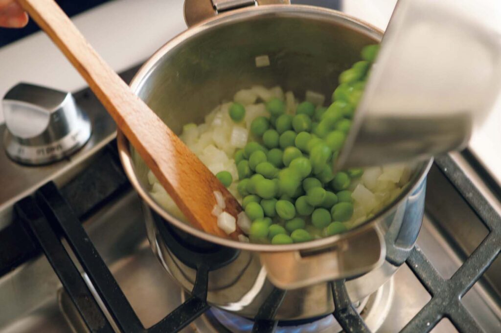 春野菜にハーブを合わせて、軽やかな洋食を。渡辺有子の料理教室3年目3月新玉ネギを炒め、透き通ってきたらグリ ーンピースを加えるタイミング。 | 新玉ネギを炒め、透き通ってきたらグリーンピースを加えるタイミング。