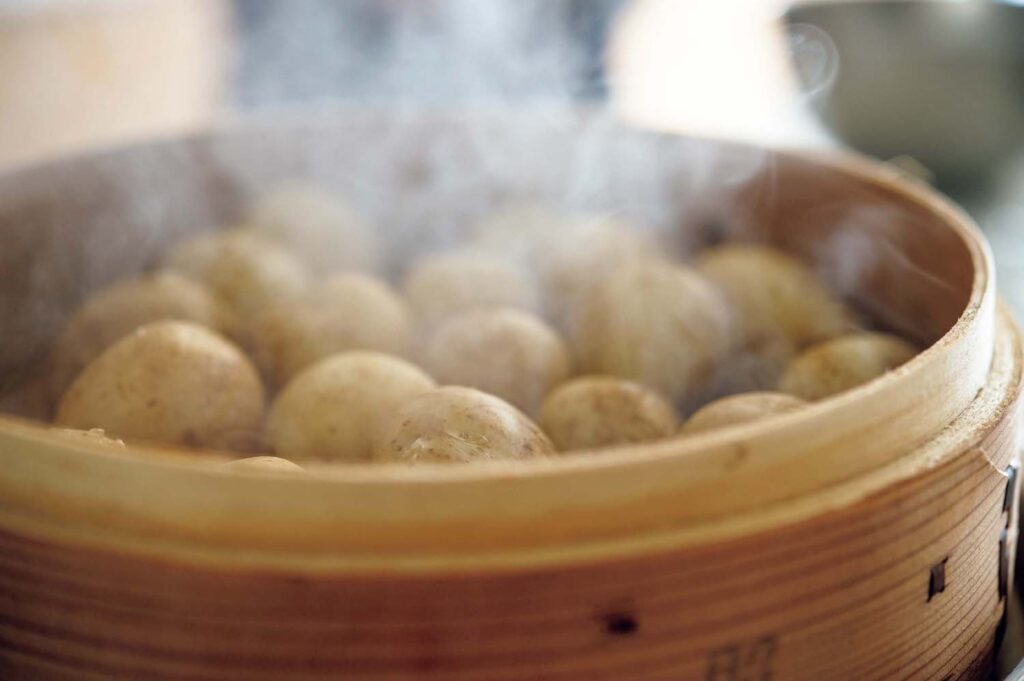 春野菜とハーブの洋食。渡辺有子の料理教室3年目3月。小ジャガイモは、十分に蒸気の上がった蒸し器でふっくらと軟らかく蒸す。 | 小ジャガイモは、十分に蒸気の上がった蒸し器でふっくらと軟らかく蒸す。