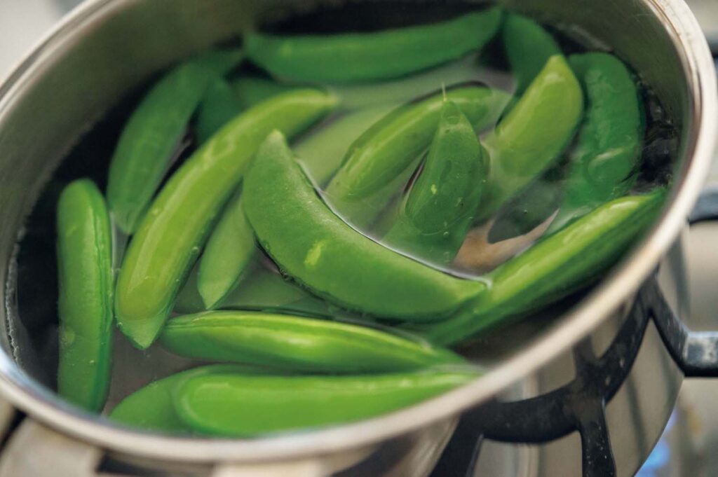 春野菜とハーブの洋食。渡辺有子の料理教室3年目3月。スナップエンドウは食感を残すために茹で時間は2分。水気をきり、サヤを開く。 | スナップエンドウは食感を残すために茹で時間は2分。水気をきり、サヤを開く。