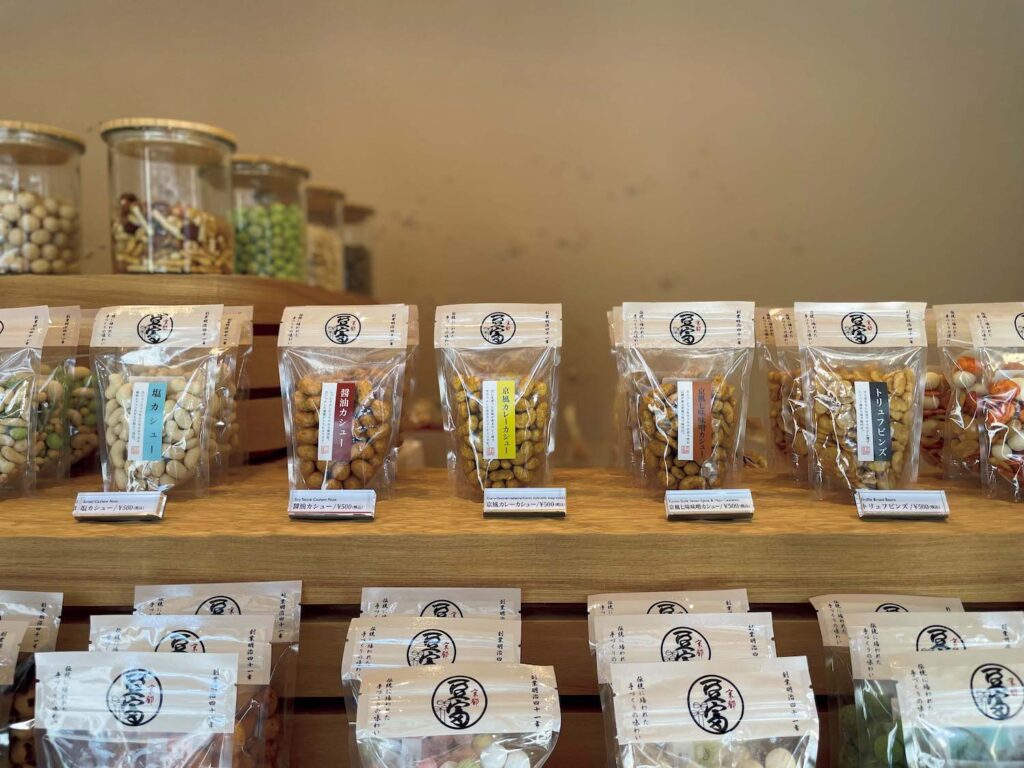 残りわずかな旅を締めるワインと土産。ニデック京都タワーに行くなら、立ち寄りたい2軒。明治41 (1908) 年創業の豆菓子専門店。2025年5月に本店が一新。種類豊富ななかで人気が高いのは京風七味味噌カシューや塩カシュー。