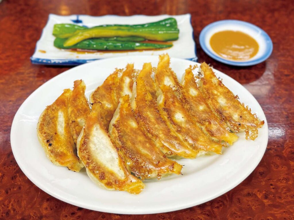 東のケーキか、西のギョーザか。東寺に行くなら、立ち寄りたい2軒。創業55年。焼きたてを味噌たれで味わう幸せ。ギョーザ1 人前￥357 (写真は2人前) 、キュウリの丸漬け￥204。