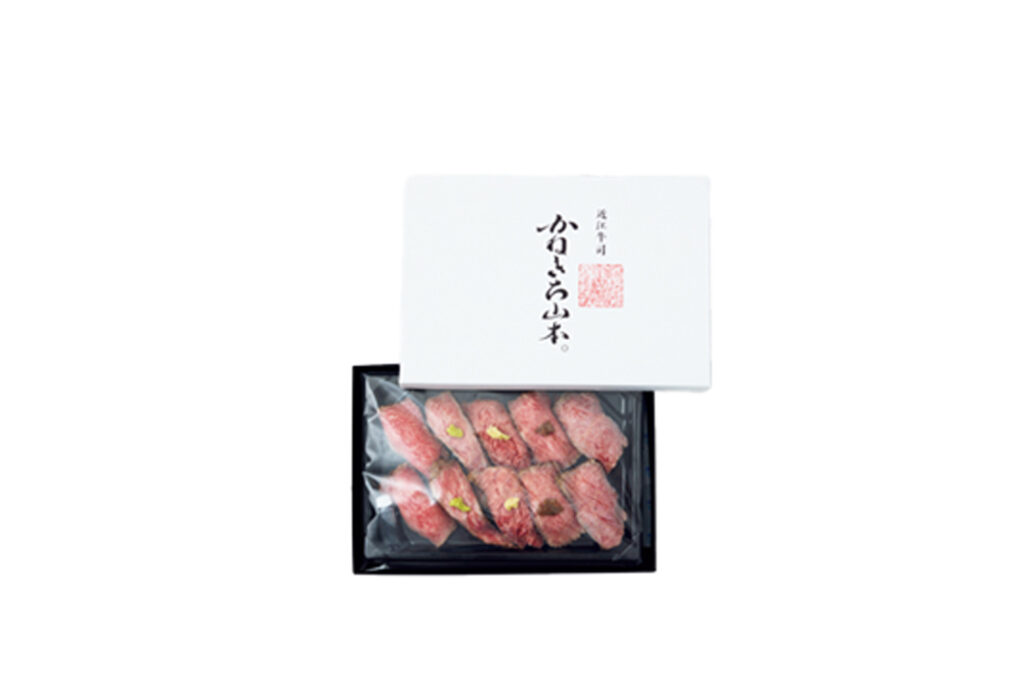 きめ細かいサシの入った赤身を使用した冷凍肉寿司。試行錯誤を重ね、約2年かけて商品化された。パッケージの箱に付属のシートを敷きお湯を注ぎ、そこにパックのまま肉寿司をのせれば解凍できる。薬味をのせた (特上) は10貫￥7,000。薬味なしの (上) は￥5,000。お待ちかね、今年の冬のお取り寄せ。ベテランフードライターのぴいさんがお贈りする厳選うまいものガイド。
