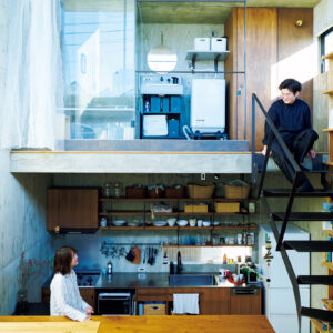 躯体の中の4層構造に暮らす。五十嵐理人さんが腰掛けているのは家の最上部の洗面所&バスルームと中2階をつなぐ鉄骨階段。妻の友子さんは、さらに半階分レベルを下げたキッチンに立っている。 | 五十嵐理人さんが腰掛けているのは家の最上部の洗面所&バスルームと中2階をつなぐ鉄骨階段。妻の友子さんは、さらに半階分レベルを下げたキッチンに立っている。 躯体の中の4層構造に暮らす。五十嵐理人さんが腰掛けているのは家の最上部の洗面所&バスルームと中2階をつなぐ鉄骨階段。妻の友子さんは、さらに半階分レベルを下げたキッチンに立っている。 | 五十嵐理人さんが腰掛けているのは家の最上部の洗面所&バスルームと中2階をつなぐ鉄骨階段。妻の友子さんは、さらに半階分レベルを下げたキッチンに立っている。