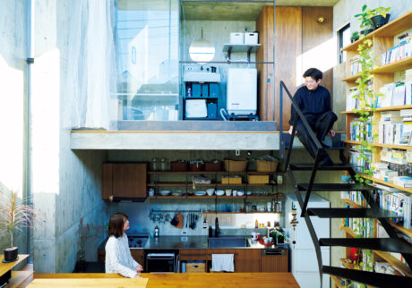 躯体の中の4層構造に暮らす。五十嵐理人さんが腰掛けているのは家の最上部の洗面所＆バスルームと中2階をつなぐ鉄骨階段。妻の友子さんは、さらに半階分レベルを下げたキッチンに立っている。 | 五十嵐理人さんが腰掛けているのは家の最上部の洗面所＆バスルームと中2階をつなぐ鉄骨階段。妻の友子さんは、さらに半階分レベルを下げたキッチンに立っている。