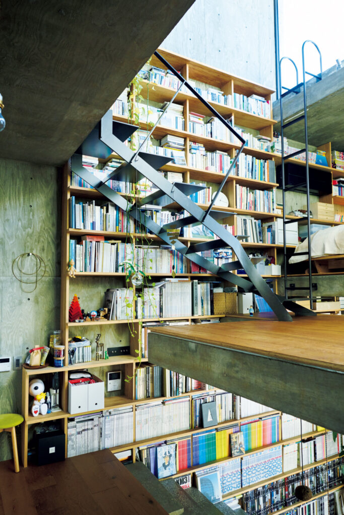 躯体の中の4層構造に暮らす。地上からキッチンに続く階段、さらにリビングへと、浮遊感のあるフロアの重なりが見える。壁面の書架の高さは約6ｍ。 | 地上からキッチンに続く階段、さらにリビングへと、浮遊感のあるフロアの重なりが見える。壁面の書架の高さは約6ｍ。